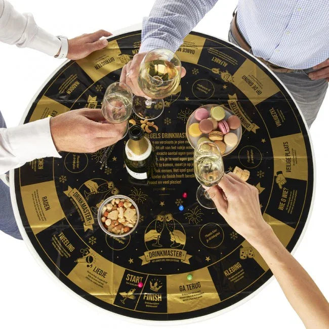 Drinkspel tafelkleed met goud-zwarte opdruk, glazen champagne, snacks en feestkleding accessoires.
